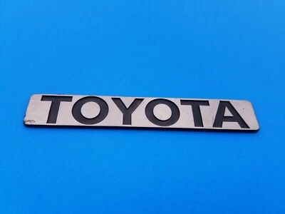 1986 1987 TOYOTA COROLLA ЗАДНЯЯ КРЫШКА БАГАЖНИКА ЭМБЛЕМА ЗНАЧОК СИМВОЛ ЛОГОТИП Б/У OEM (1987) - Изображение 1 из 3