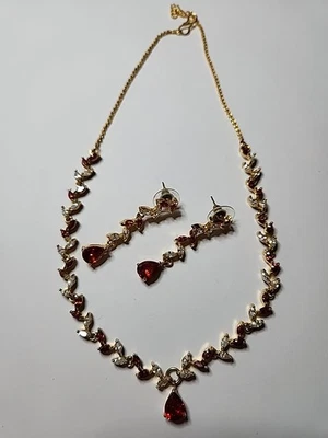 Juego de collar y pendientes de diamantes de imitación. Diseño hoja, piedras rojas/blancas con tono dorado. Foto 1 de 2