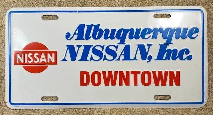 Albuquerque New Mexico Nissan Booster License Plate Vintage Dealer Downtown  - Image 1 of 1