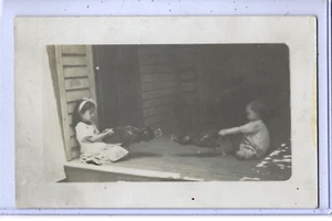 Real Photo Postcard RPPC - Girl and Boy Holding Roosters Fighting - Picture 1 of 2