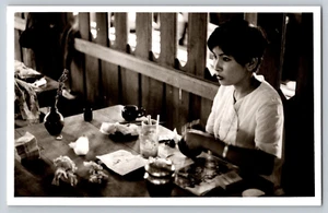Fotografia Vietnam durante la guerra del Vietnam signora seduta a tavola drink con cannuccia - Foto 1 di 2