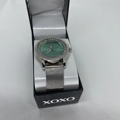 Reloj analógico para mujer XOXO con correa plateada/cara verde azulado/necesita pilas Foto 1 de 4