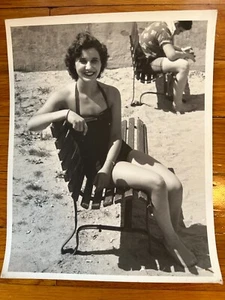 VTG 1950s 8x10 B&W PHOTO BEACH SCENE BRUNETTE HALTER SWIMSUIT SITTING ON BENCH - Picture 1 of 1