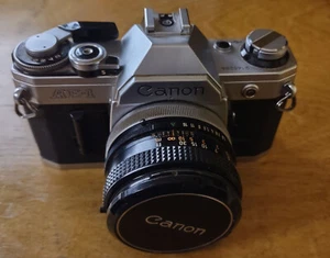 Canon AE-1 Kamera mit Objektiv, Objektivdeckel und Handbuch - Bild 1 von 5