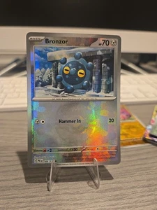 Pokémon TCG Bronzor 066/131 Meisterball Holo Prismatic Evolutions NM/M - Bild 1 von 3
