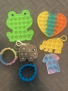 POP IT SET 7 STCK. KLEINE MITTEL ARMBÄNDER SCHLÜSSELANHÄNGER FROSCH HERZ ELEFANT NASHORN - Bild 1 von 4