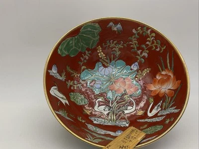 Fondo rojo coral con esmaltes multicolores con flores de loto y cuenco grullas Foto 1 de 4