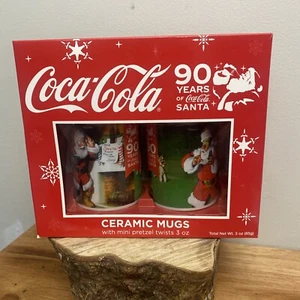 NEU 90 Jahre Coca Cola Weihnachtsmann Sammlerstück Keramik Becher Set mit Mini Brezeln - Bild 1 von 5