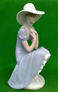 11" NAO / LLADRO - PENSIVE GIRL IN LARGE SUNHAT SITTING ON A ROCK WALL. - Picture 1 of 12