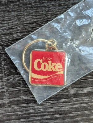 VINTAGE ENJOY COKE COCA~COLA RED GOLD TONE KEYCHAIN 1.25" x 1.25" - SEALED RARE - Image 1 of 4