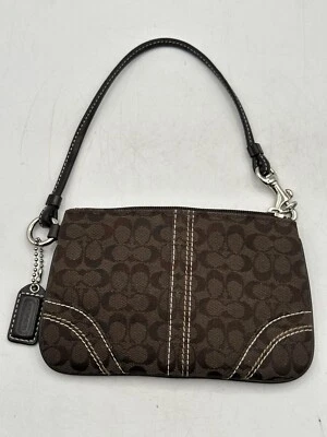 Muñequera Coach de tela marrón con dije de bolso tono plateado herrajes cierre de cremallera Foto 1 de 4