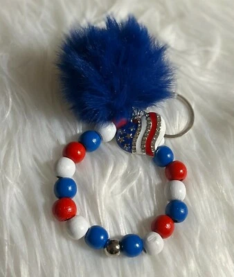 Браслет-брелок ручной работы из красных, белых и синих деревянных бусин с подвеской-помпончиком  - Изображение 1 из 4