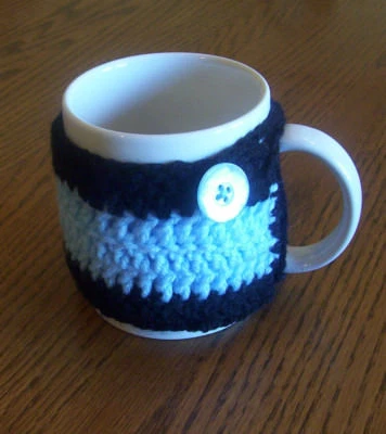 Caneca de café aconchegante de crochê manual preta e azul bebê abotoada - Imagem 1 de 3