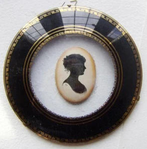 SILHOUETTEN EINE JUNGE DAME AUF EMAILLE OVAL IN FEINEM RUNDEM EGLOMISE RAHMEN UM 1850 - Bild 1 von 1