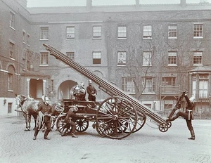 Uniformed firemen demonstrating a horse-drawn escape vehicle in co- Old Photo - Bild 1 von 1