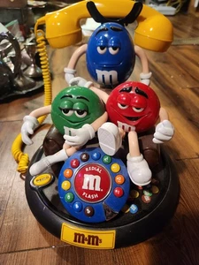 M&M ANIMIERTES TELEFON LIZENZIERT ROT GRÜN & BLAU M&M'S AUF BRAUNER COUCH - Bild 1 von 5
