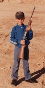 Boy Holding Rifle Blue Jacket Dusty Landscape Confident Outdoors 1980s - Picture 1 of 3
