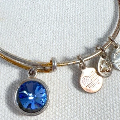 Brazalete expandible Alex And Ani tono dorado con detalles de cristal azul y dije Foto 1 de 4