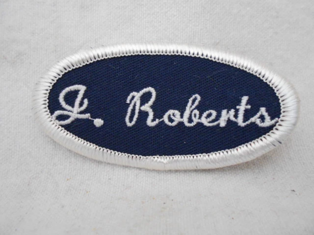 J. ROBERTS USED EMBROIDERED  SEW ON NAME PATCH TAG OVAL BLACK ON WHITE - Image 1 of 1