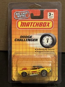 1990 Matchbox MB1 Yellow "Toyman" Dodge Challenger on Card with Protector - Picture 1 of 2