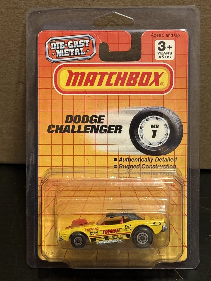 1990 Matchbox MB1 Yellow "Toyman" Dodge Challenger on Card with Protector - Image 1 of 2