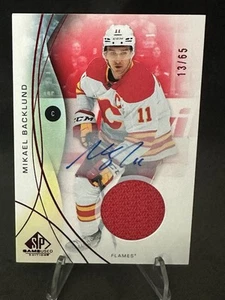 2024-25 UD SP GAME-USED #85 MIKAEL BACKLUND GAME-USATO RED AUTO JERSEY /65 FIAMME - Foto 1 di 2