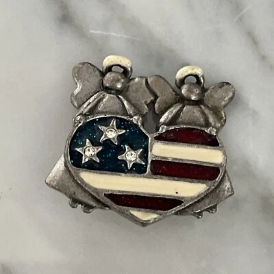 Prendedor patriótico de peltre y esmalte AJMC ángeles dobles sosteniendo bandera de Estados Unidos en forma de corazón Foto 1 de 4