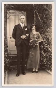 Tall Man Standing with Woman Holding Flowers RPPC Real Photo Postcard - Picture 1 of 2