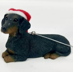 Perro Dachshund de pelo corto negro en sombrero de Santa adorno de Navidad. - Imagen 1 de 5