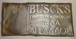 Placa de letrero BUSCK'S LECHE DE VACA CONDENSADA DINAMARCA GRIEGA ESTAÑO METAL EN RELIEVE AÑOS 40 - Imagen 1 de 5