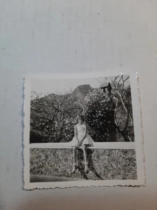 Foto instantánea vintage de los años 50 en blanco y negro de niña de 2 1/4" x 2 1/4" sentada en la pared PB55 - Imagen 1 de 1