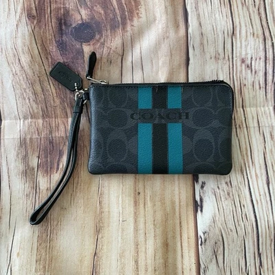 Muñequera billetera pequeña de PVC negra de mezclilla COACH Varsity Signature Foto 1 de 4