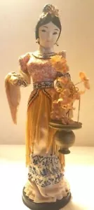 BAMBOLA ASIATICA VINTAGE SU SUPPORTO CON VASO DI FIORI, BROCCATO E FRANGE SETA ORNAMENTALE - Foto 1 di 6