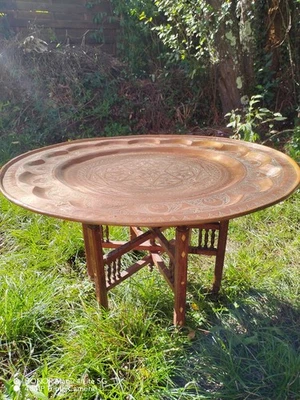 Grande table basse ancienne en cuivre rouge martelée sur pieds en bois sculpté - Photo 1/4