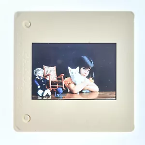 Vintage Rutsche. Niedlichkeit in Hülle und Fülle. Kleines Mädchen, junges Kätzchen mit Puppe und Spielzeugstuhl. - Bild 1 von 3