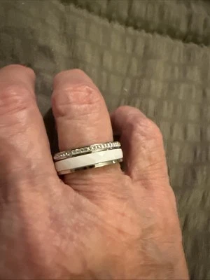 Hermoso anillo de titanio blanco talla 7 con pedrería plateada alrededor de un borde Foto 1 de 4