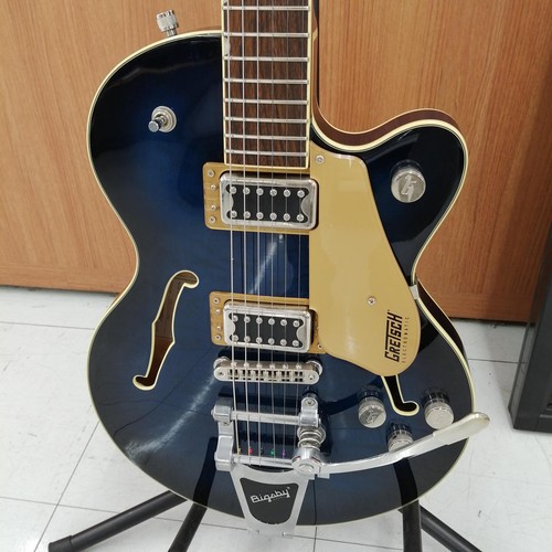 Black GRETSCH G5655T-QM hollow body electric guitar with gold hardware, six strings, and distinctive “GRETSCH” on neck.