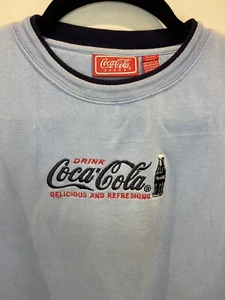 Hellblauer Baumwollpullover mit Rundhalsausschnitt der Marke Coca Cola - XL  - Bild 1 von 5