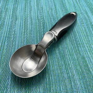 Cuchara de helado OXO Good Grips con liberación de palanca para pulgar de acero inoxidable con mango negro - Imagen 1 de 8