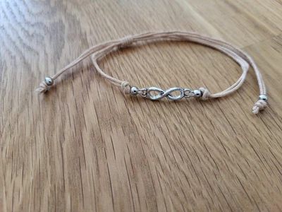 Armband  beige mit silbernem Infinity Anhänger größenverstellbar von Accessorize - Bild 1 von 2