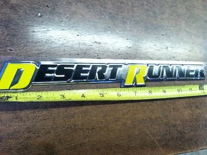 EMBLEMA OEM NISSAN ""DESERT RUNNER"" - NEGRO AMARILLO - FRONTERA / TITANIO - Imagen 1 de 3