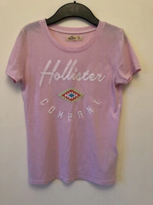Camiseta Hollister Rosa Claro Logo Bordado Con Diseño Geométrico Talla XS Foto 1 de 3