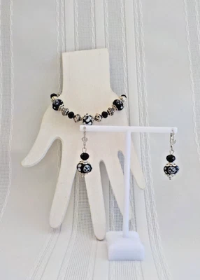 Conjunto de pendientes perforados pulsera de cuentas de vidrio blanco y negro palanca de metal remolino Foto 1 de 4