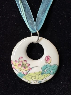 Colorido colgante de cerámica sobre collar de cinta azul Foto 1 de 4