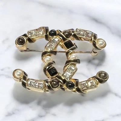 Broche Chanel cristal baguete pérola/resina CC ouro/preto/branco perolado com espanador - Imagem 1 de 4
