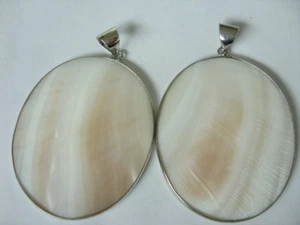 Ein 55 mm creme weißer ovaler Perlmutt Ketten Anhänger gefasst leicht gebogen - Bild 1 von 2