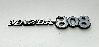 Mazda 808 1971-1978 guardabarros delantero emblema insignia adorno moldura Foto 1 de 4