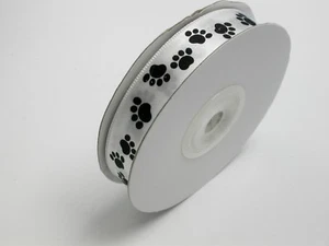 Cinta satinada con estampado de pata 5/8" (15,8 mm) blanca con estampados de pata negra 25 yardas - Imagen 1 de 1