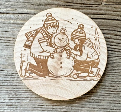 Wooden Nickel Geocoin-Kids Building Snowman - Image 1 of 2