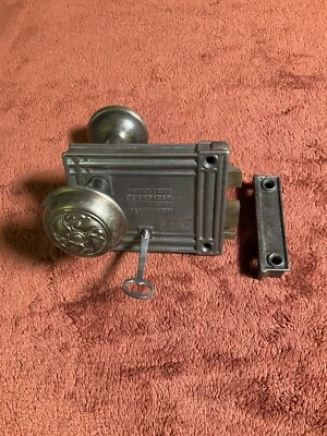 Acero antiguo M.W. Juego de cerraduras de puerta con borde Co., lanzamientos de latón, 2 perillas decorativas, 1 llave Foto 1 de 4